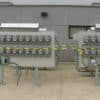 Custom semi-circular electric meter farm installation, structurally integrated to match curved commercial building architecture and footprint profiles.